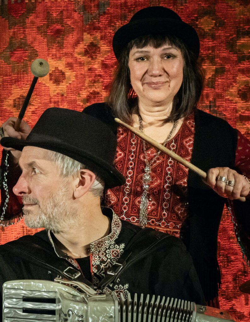 Muzycy w tradycyjnych strojach, grający na instrumentach.